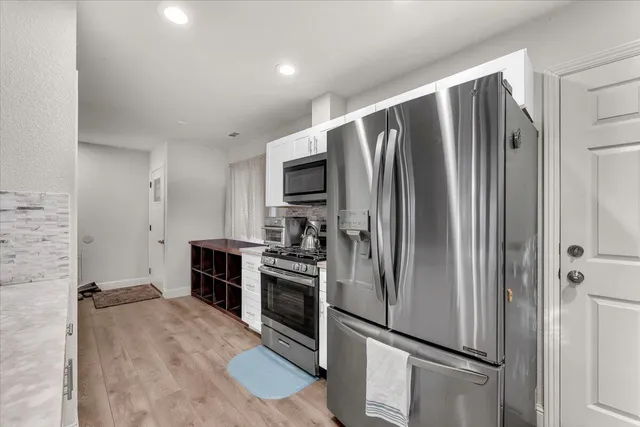 a kitchen with stainless steel appliances granite countertop a refrigerator sink and stove