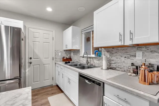 a kitchen with stainless steel appliances white cabinets and a refrigerator