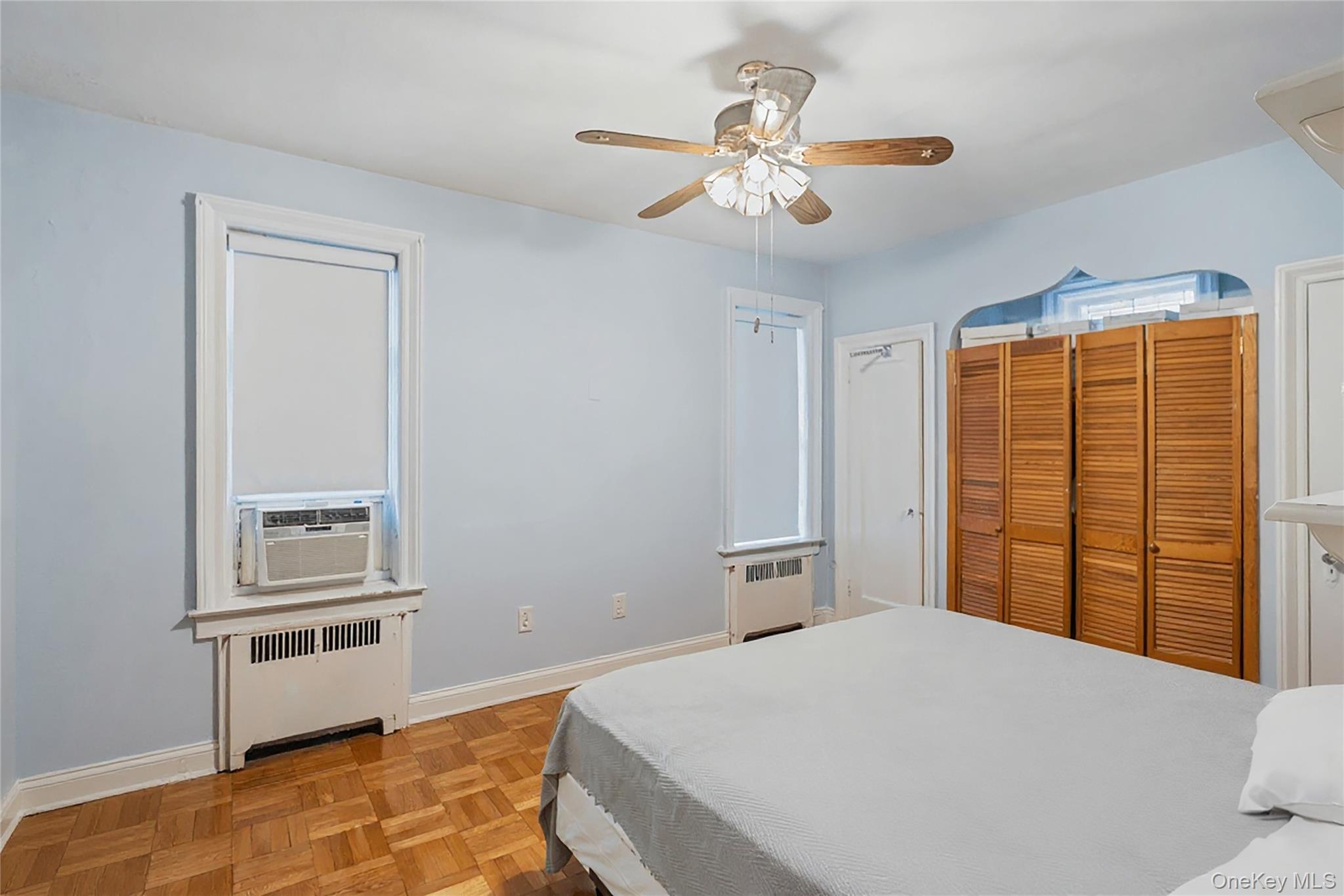 1527 East 29th Street Brooklyn, NY 11229 - Photo 8 of 22 Bedroom featuring radiator heating unit, a closet, ceiling fan, and cooling unit