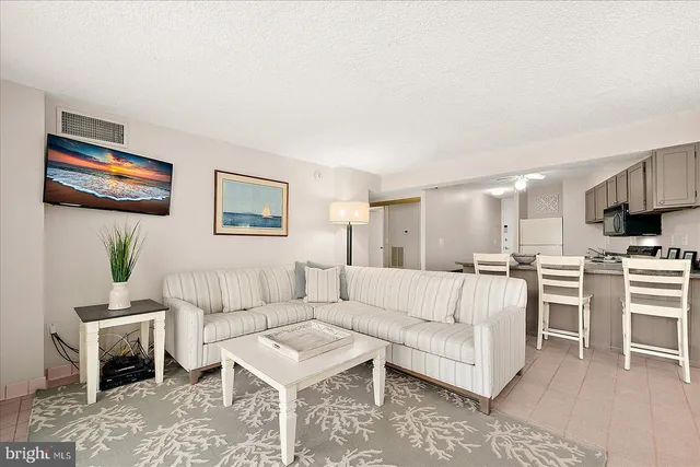 a living room with furniture a dining table and kitchen view