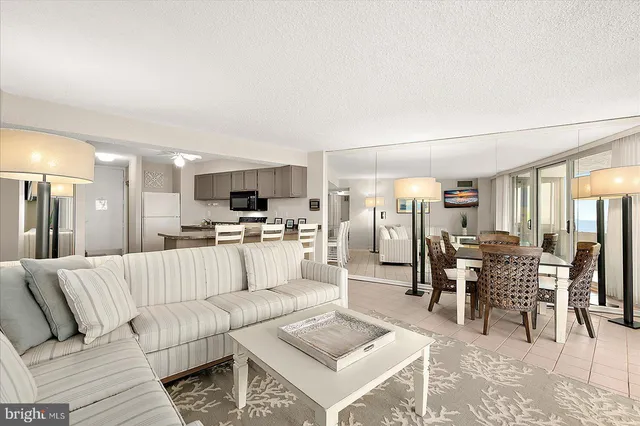 a living room with furniture and view of kitchen