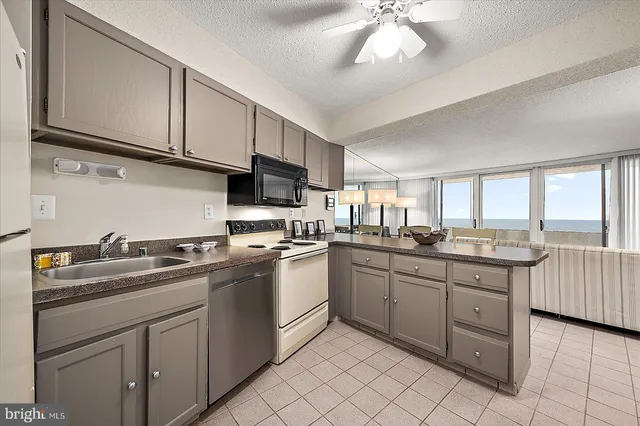 a kitchen with sink a microwave and cabinets