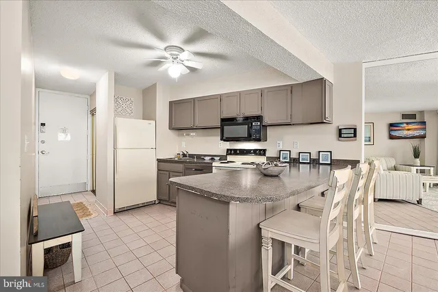 a kitchen with kitchen island a counter top space appliances and cabinets