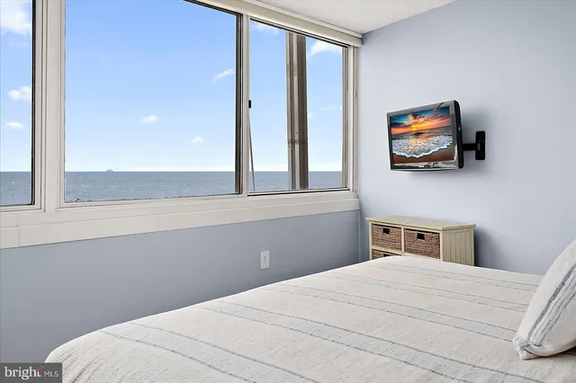 a bedroom with a bed and a flat tv screen on the dresser