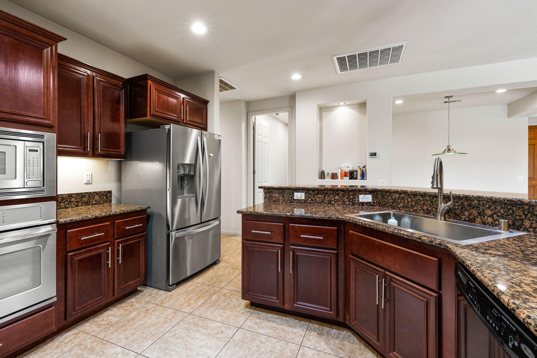 83725 Himalaya Drive Indio, CA 92203 - Photo 19 of 45 a kitchen with granite countertop stainless steel appliances and wooden cabinets