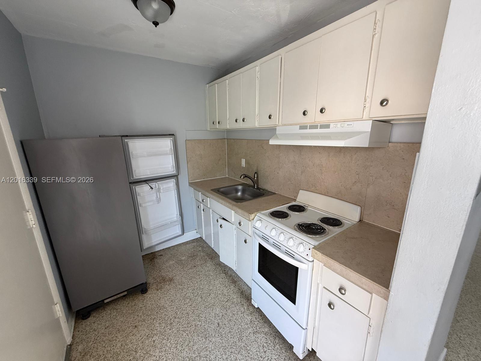 990 Southwest 4th Street, Unit 6 Miami, FL 33130 - Photo 6 of 6 a kitchen with white cabinets and white appliances