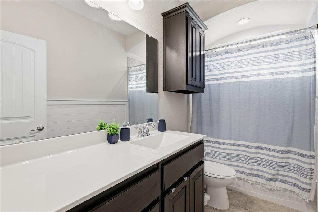 11500 Starlight Ranch Fort Worth, TX 76052 - Photo 26 of 40 Bathroom featuring a white vanity with a rectangular sink and dark cabinetry, a large mirror, and a toilet