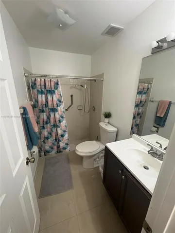 a bathroom with a double vanity sink mirror and toilet