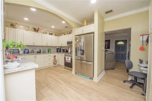 a kitchen with a refrigerator and white cabinets