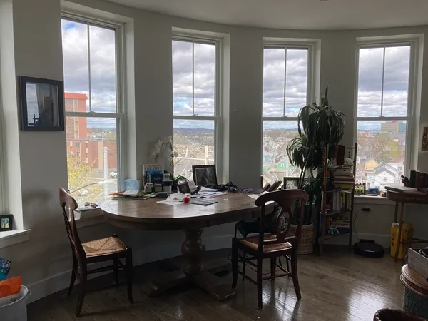 a dining room with furniture window and wooden floor