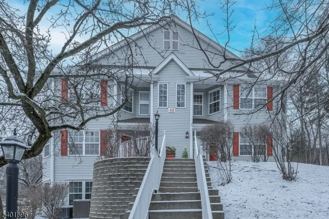 a view of a brick house with large trees