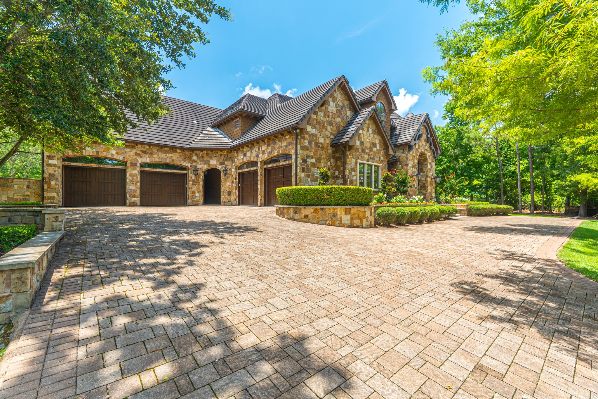 247 South Fazio Way Spring, TX 77389 - Photo 6 of 17 A grand arrival begins with an expansive motor court, timeless stone architecture, and a six-car garage, setting the tone for the exceptional craftsmanship found throughout this exceptional estate.