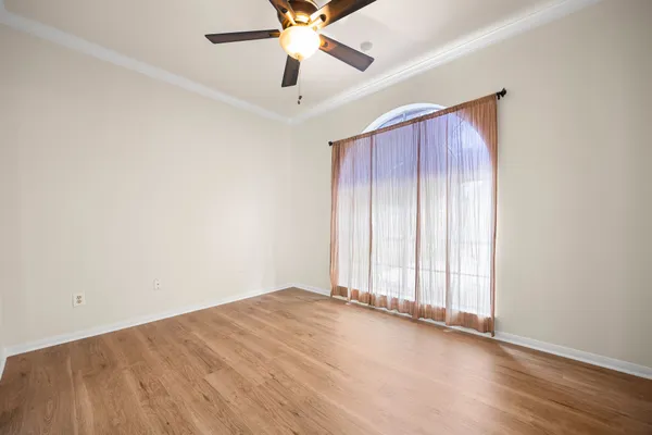 a view of empty room with wooden floor and windows