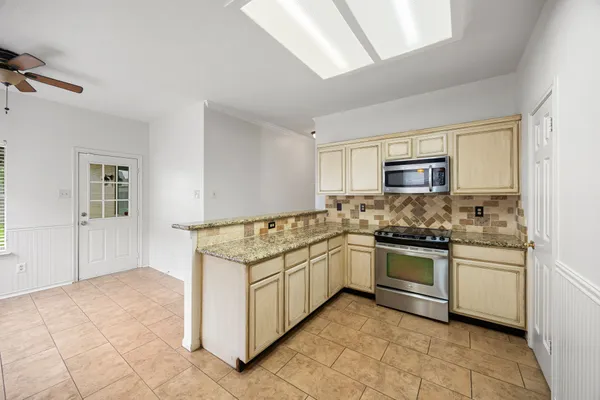 a kitchen with stainless steel appliances granite countertop a sink and a refrigerator