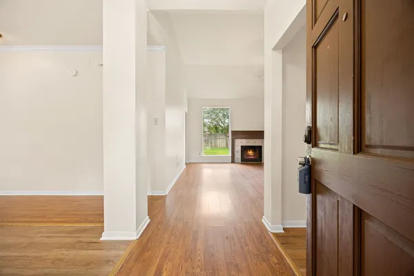 a view of an empty room with a window and fireplace