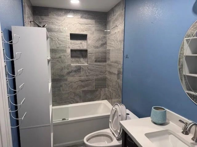 a bathroom with a granite countertop toilet sink and shower