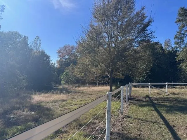 a view of a yard with wooden fence