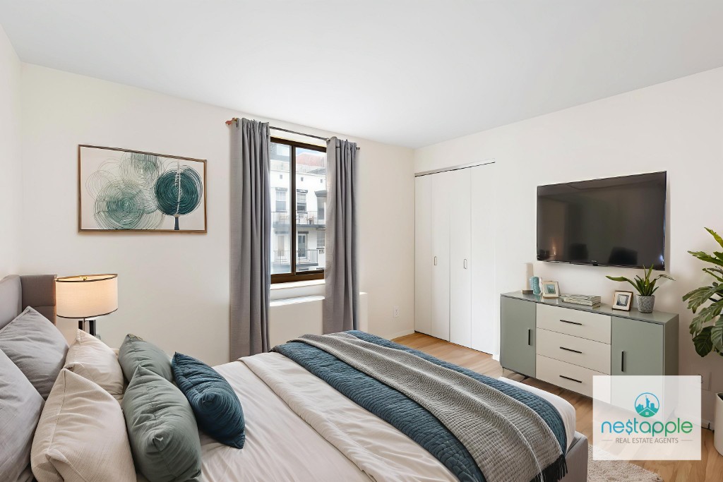 445 West 19th Street, Unit 5C Manhattan, NY 10011 - Photo 2 of 5 a bedroom with a bed and a flat screen tv