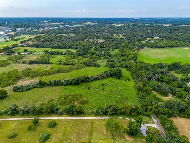 an aerial view of residential houses with outdoor space and lake view