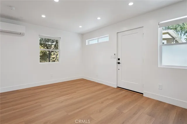 an empty room with wooden floor and window