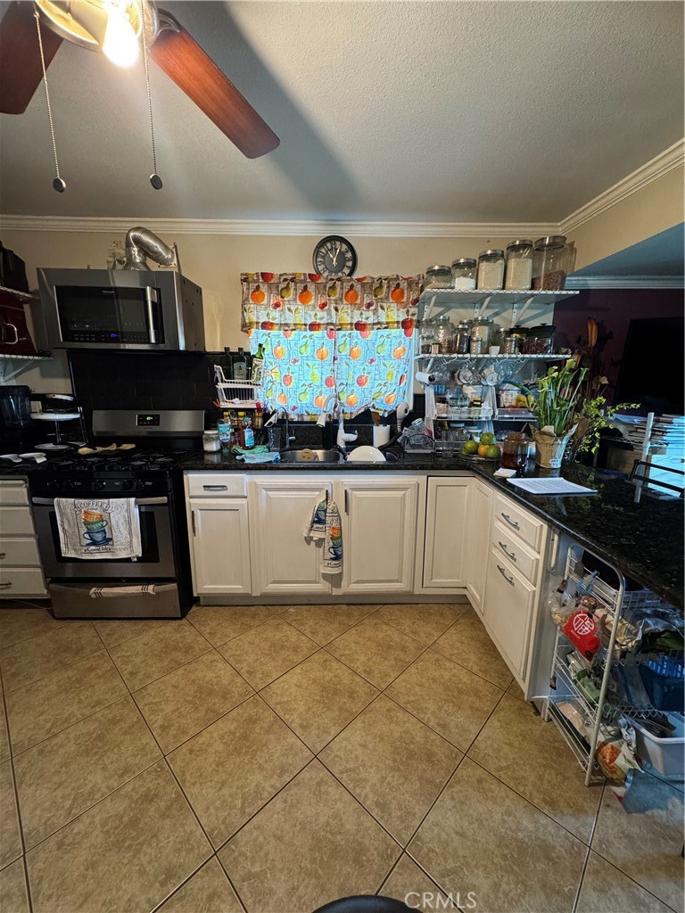 6045 Mission Boulevard, Unit 13 Riverside, CA 92509 - Photo 3 of 7 a kitchen with stainless steel appliances granite countertop a sink and cabinets