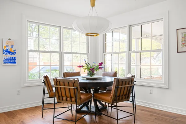 a dining room with furniture a chandelier and wooden floor