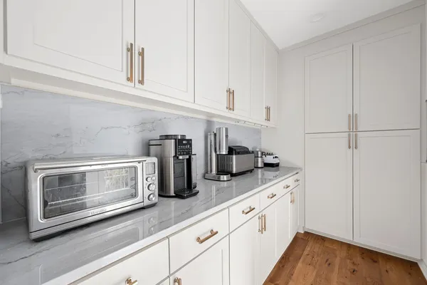a kitchen with granite countertop white cabinets and white appliances