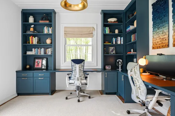 a view of a workspace with furniture and a window