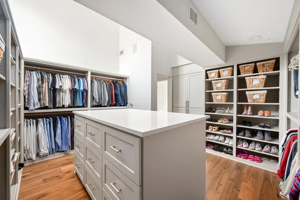 a view of walk in closet with clothes and shoes