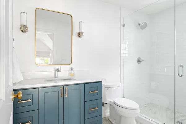 a bathroom with a granite countertop sink toilet a mirror and shower