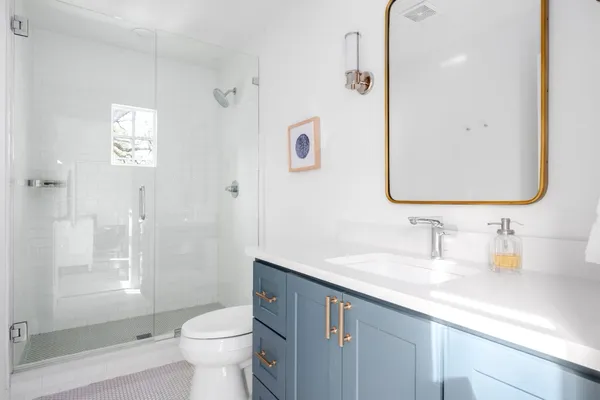 a bathroom with a sink a toilet and shower