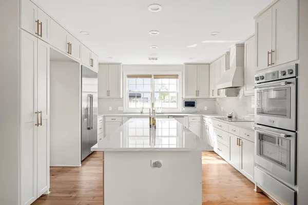 a kitchen with white cabinets and stainless steel appliances