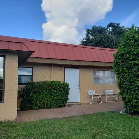 a view of backyard of house with green space
