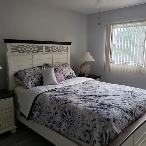 a bed sitting in a bedroom next to a window