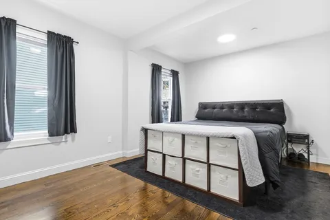 a bedroom with a bed a window and dresser