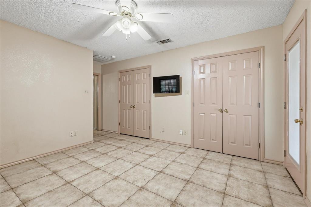 135 Private Road 2202 Decatur, TX 76234 - Photo 20 of 40 Unfurnished bedroom with multiple closets, a textured ceiling, and a ceiling fan