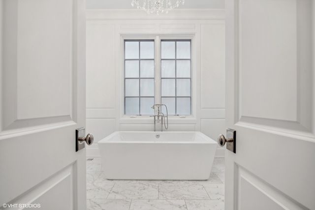 a bathroom with a double vanity sink a mirror a bathtub and shower