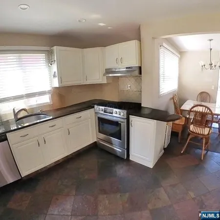 a kitchen with granite countertop white cabinets and white appliances