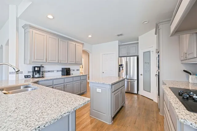 a kitchen with granite countertop a sink stove and refrigerator