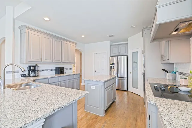 a kitchen with stainless steel appliances granite countertop a sink stove and refrigerator