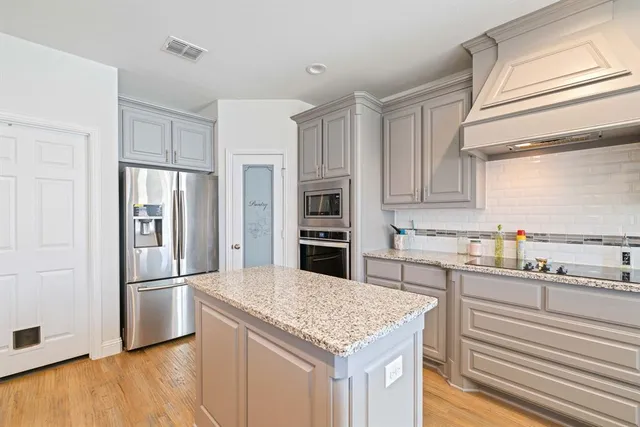 a kitchen with stainless steel appliances granite countertop a refrigerator and a sink