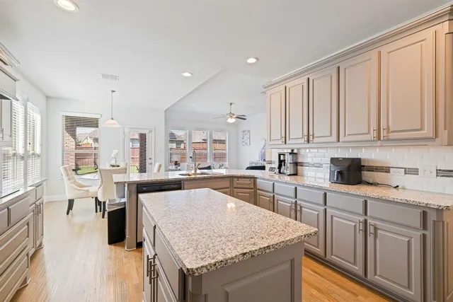 a kitchen with stainless steel appliances granite countertop hardwood floor sink stove and granite counter top