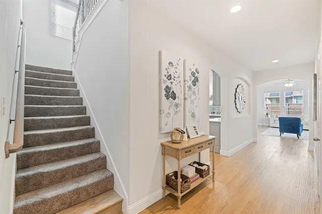 a view of a room with lots of white furniture and wooden floor