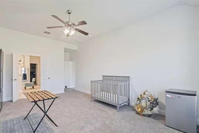 a room with chandelier fan and wooden floor