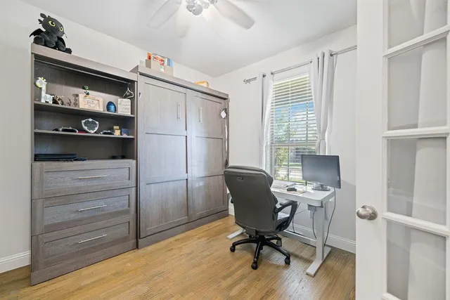 a view of a workspace with furniture and a window