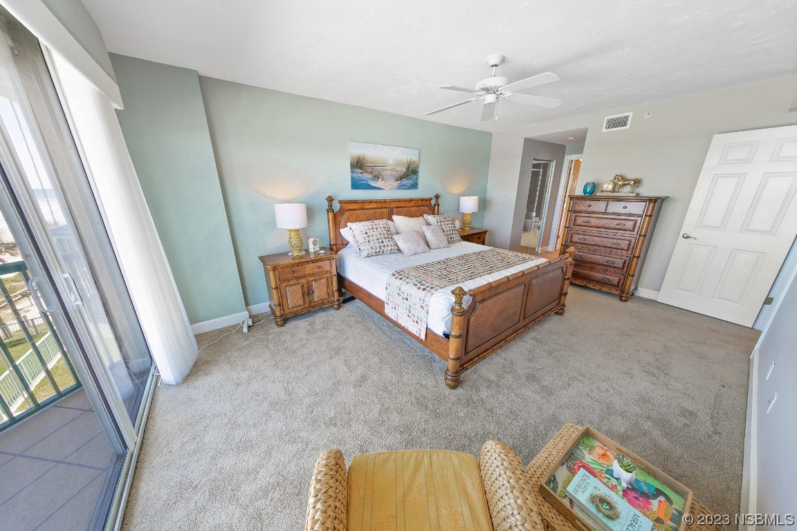 4575 South Atlantic Avenue, Unit 6307 Ponce Inlet, FL 32127 - Photo 19 of 36 a bedroom with a bed and a chandelier