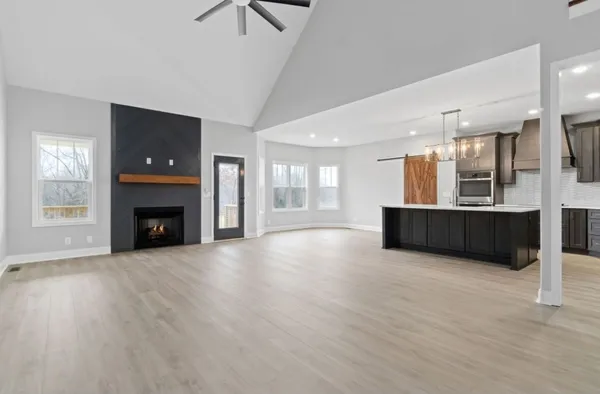 a view of an empty room with a fireplace and a window
