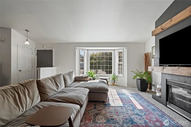 a living room with furniture a flat screen tv and a fireplace