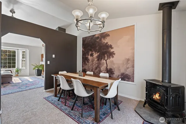a view of a dining room with furniture a chandelier windows and wooden floor
