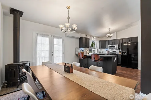 a kitchen with sink refrigerator dining table and chairs